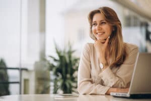 mulher feliz com mao no queixo acabou de aprender sobre a disponibilidade FNe de sua empresa para não perder o time